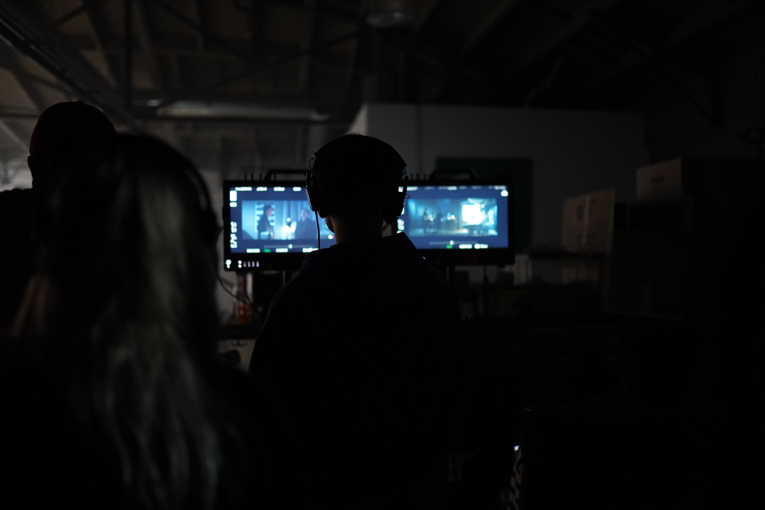 Director watching monitors on a dark film set